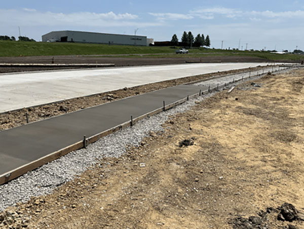 Newly constructed concrete sidewalk alongside a roadway